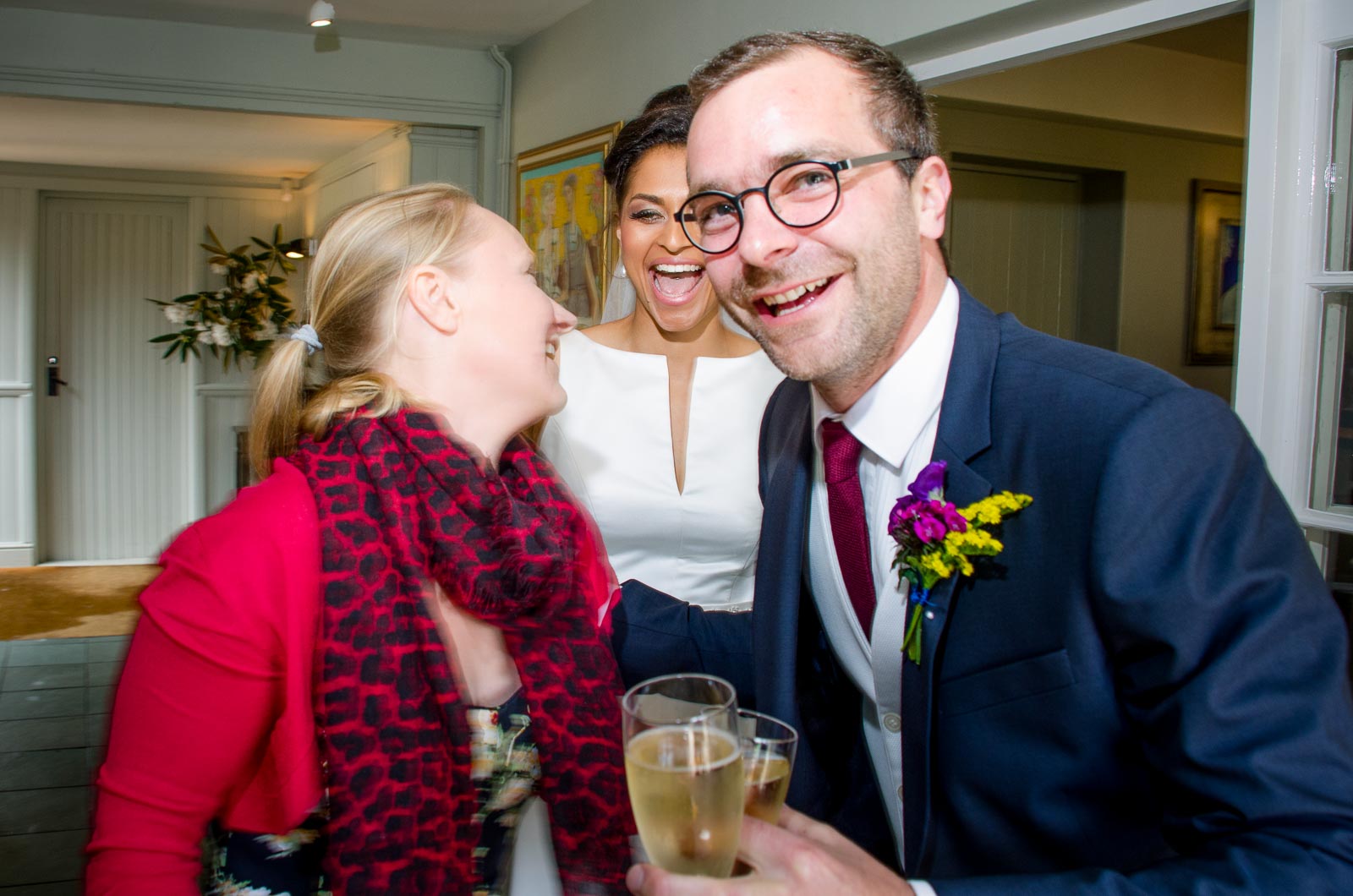 Raf, Tash and a wedding guest laugh during their wedding reception in Borde Hill, Haywards Heath.