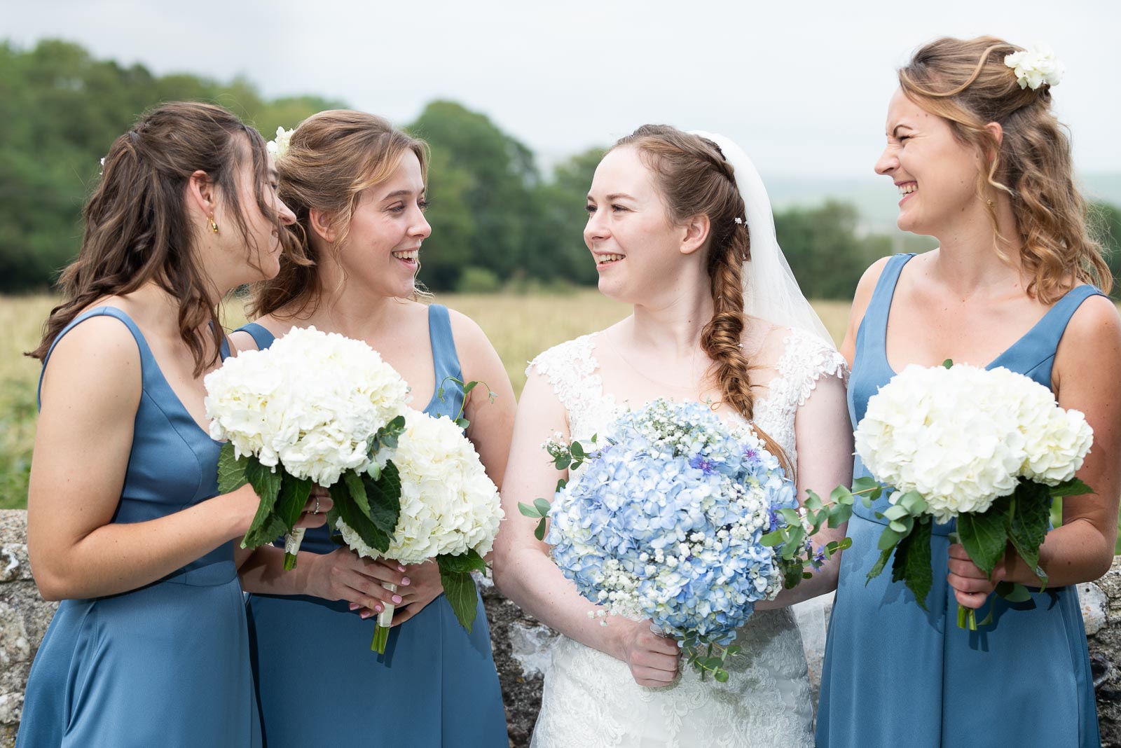 Lily chats with her bridesmaids after getting married to Callum at St Nicholas Church in Iford.