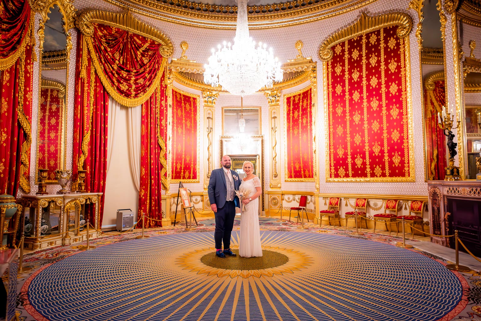 Georgina and Andy smile in the beautifully decorated Saloon in Brighton Royal Pavilion after their wedding.