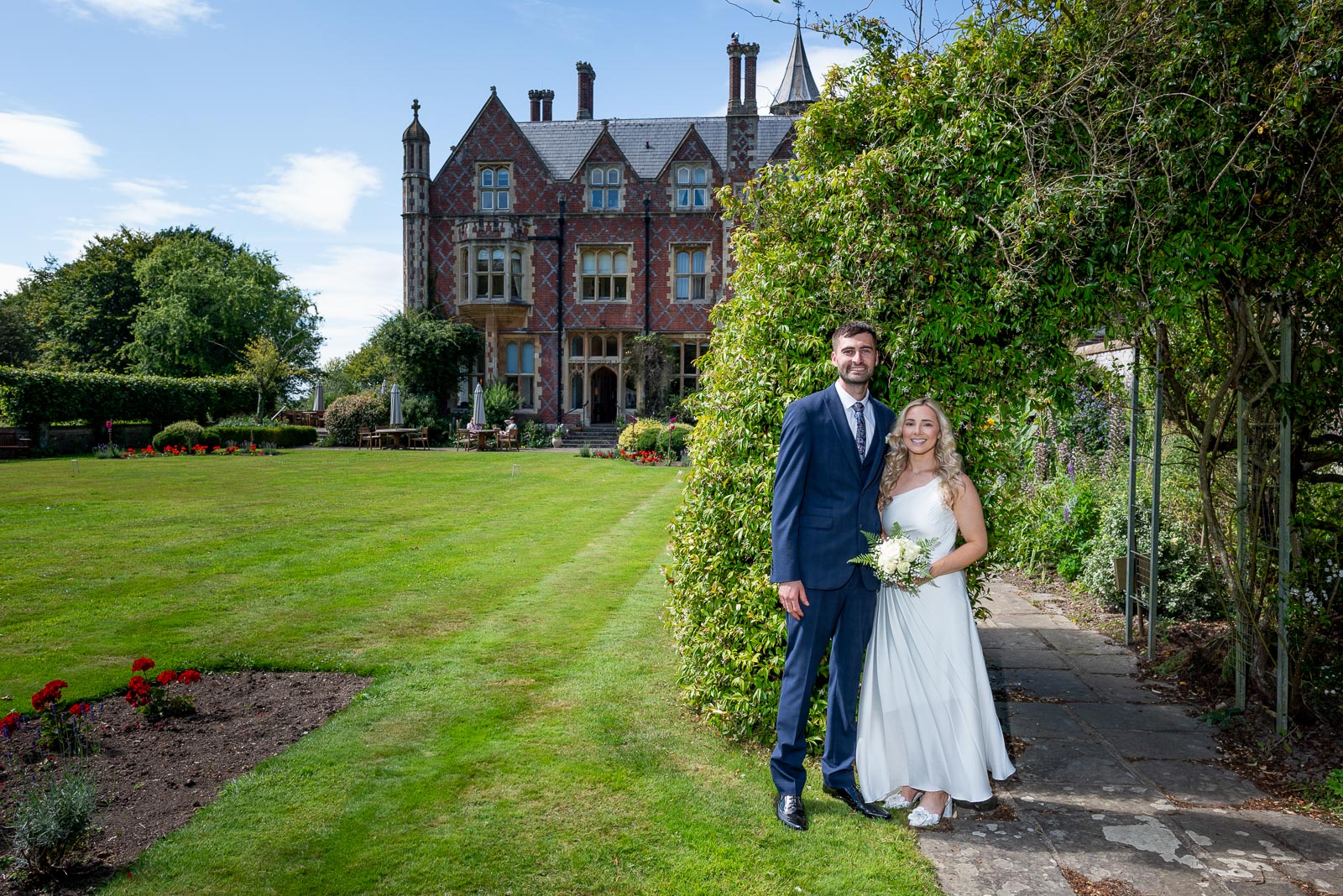 Fred and Jess pose in one of the leafed arches of Horsted Place Hotel's garden.