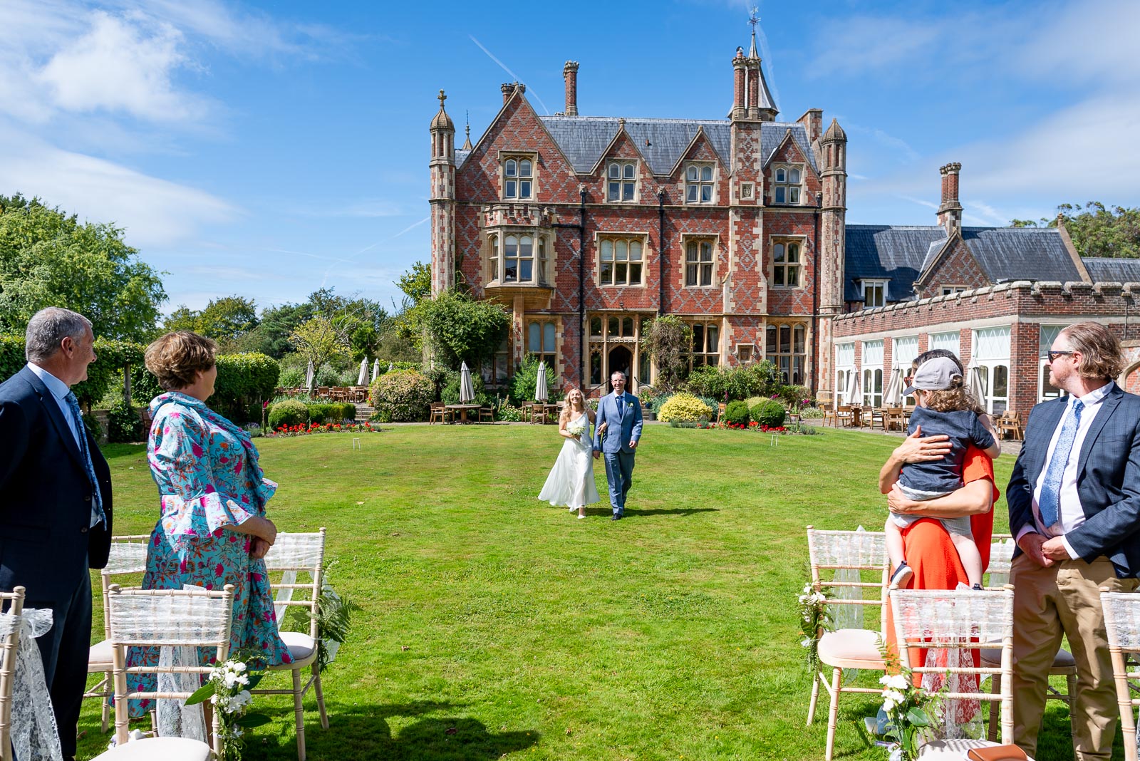 Jess is accompanies by her father as she walks down the garden in Horsted Place Hotel before her wedding to Fred.