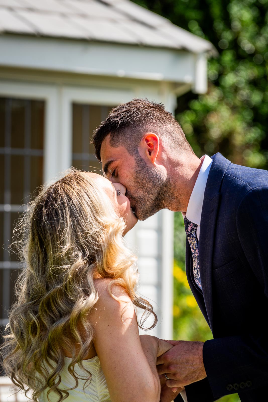 Jess and Fred kiss after their wedding in the gardens at Horsted Place Hotel.