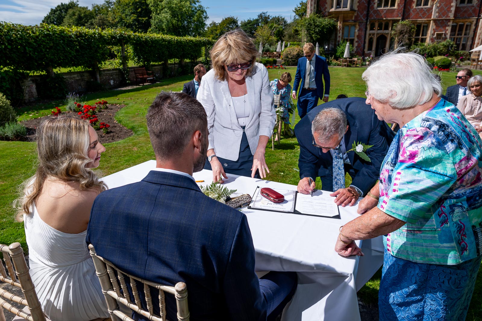 Jess and Fred are surrounded by their witnesses during their wedding in the gardens at Horsted Place Hotel.